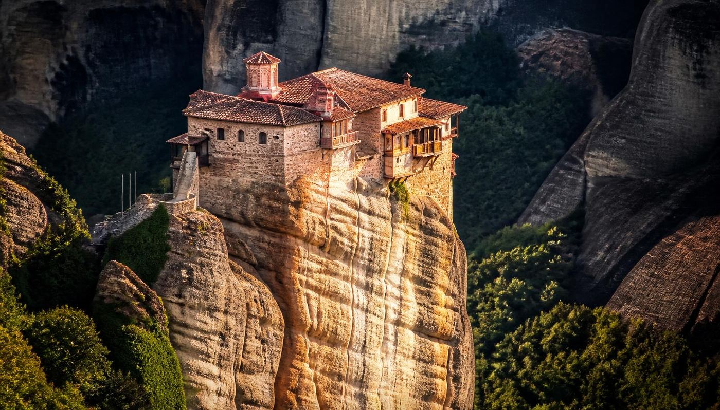 Roussanou Monastery in Meteora built across the entire top of a sandstone pillar in warm evening light